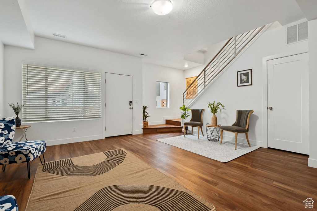 Foyer with wood finished floors, baseboards, and stairway