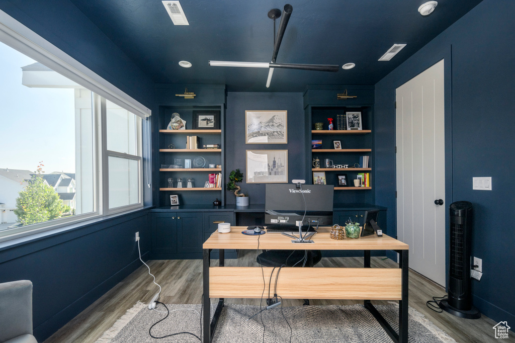 Home office featuring light wood-style flooring, ceiling fan, and baseboards