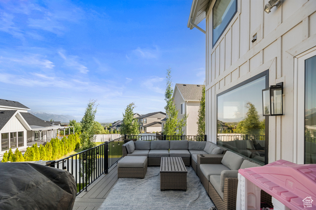 Wooden terrace with an outdoor hangout area and a residential view