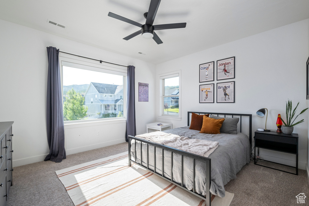 Bedroom featuring light carpet, baseboards, and a ceiling fan