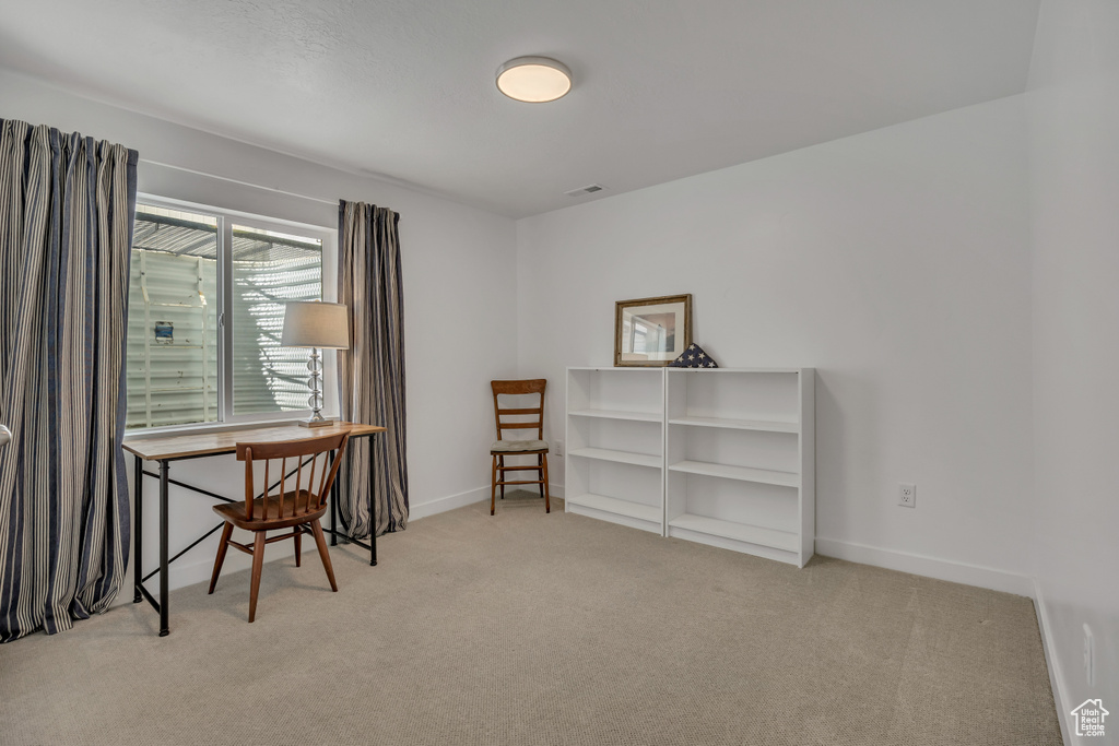 Carpeted home office featuring baseboards