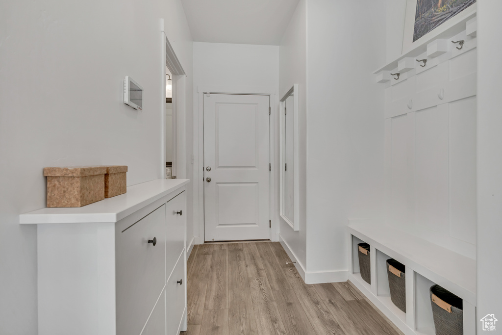Mudroom with light wood finished floors and baseboards