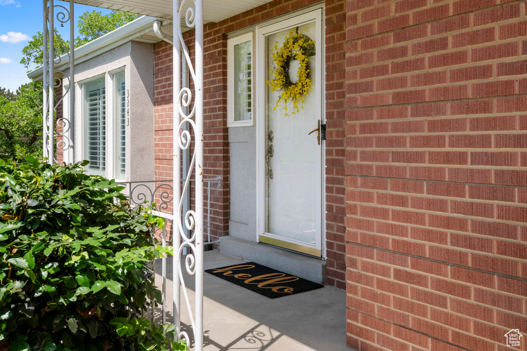 Doorway to property featuring brick siding