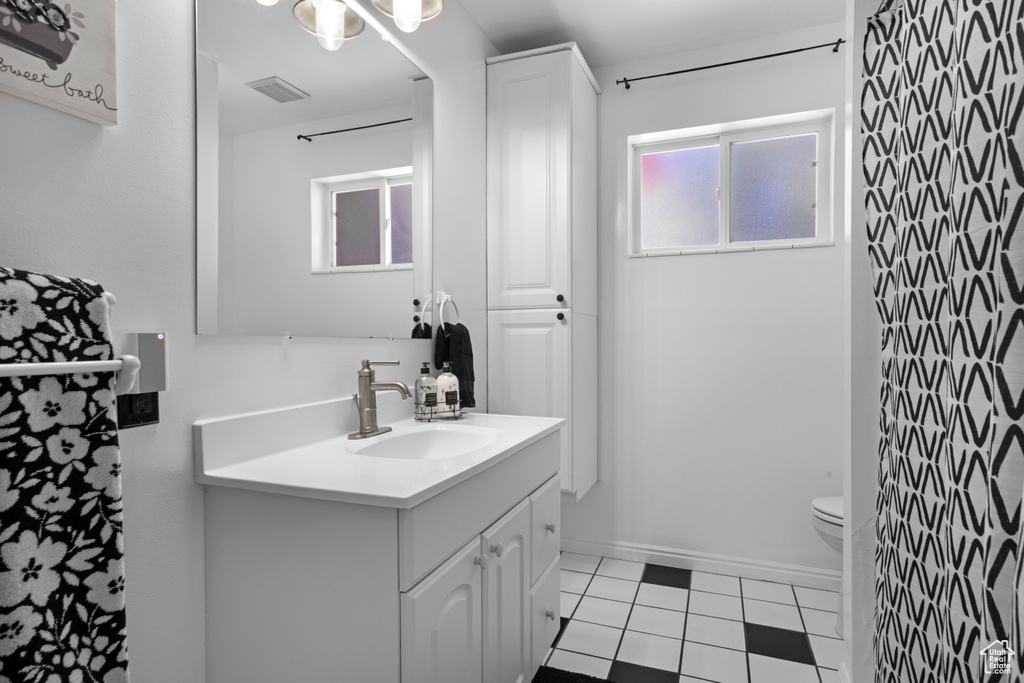 Full bath with vanity, toilet, and tile patterned floors