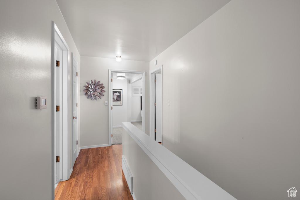 Corridor featuring light wood-style floors and baseboards