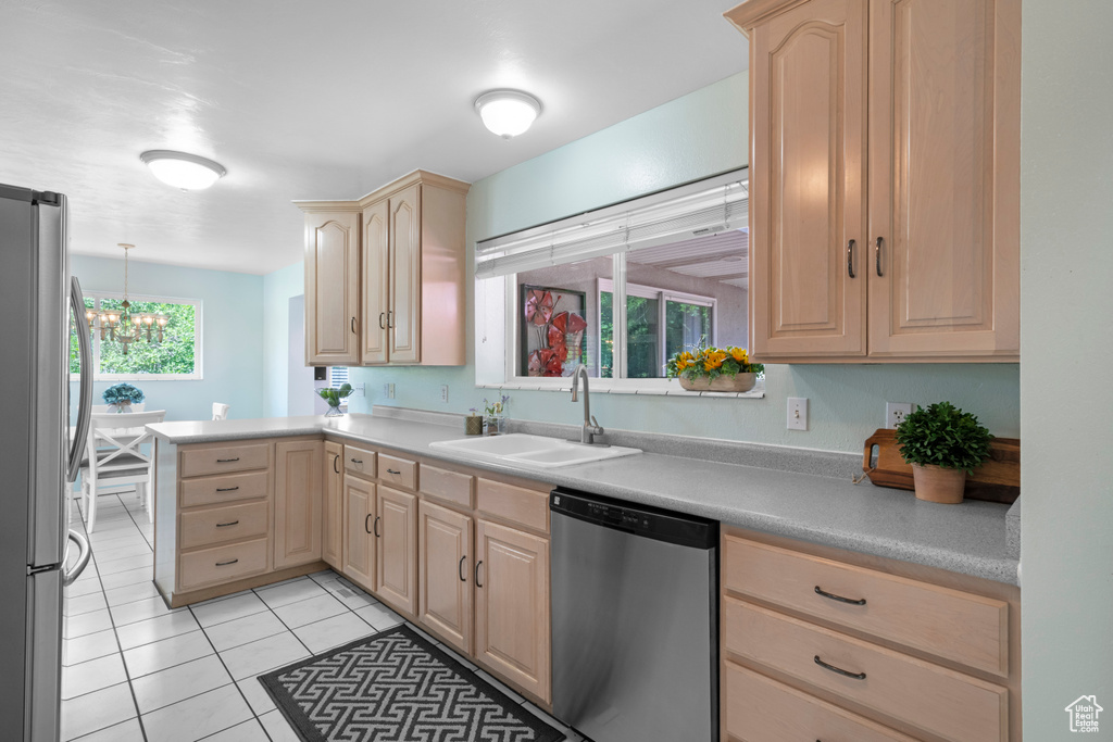 Kitchen featuring stainless steel appliances, light brown cabinets, and a sink