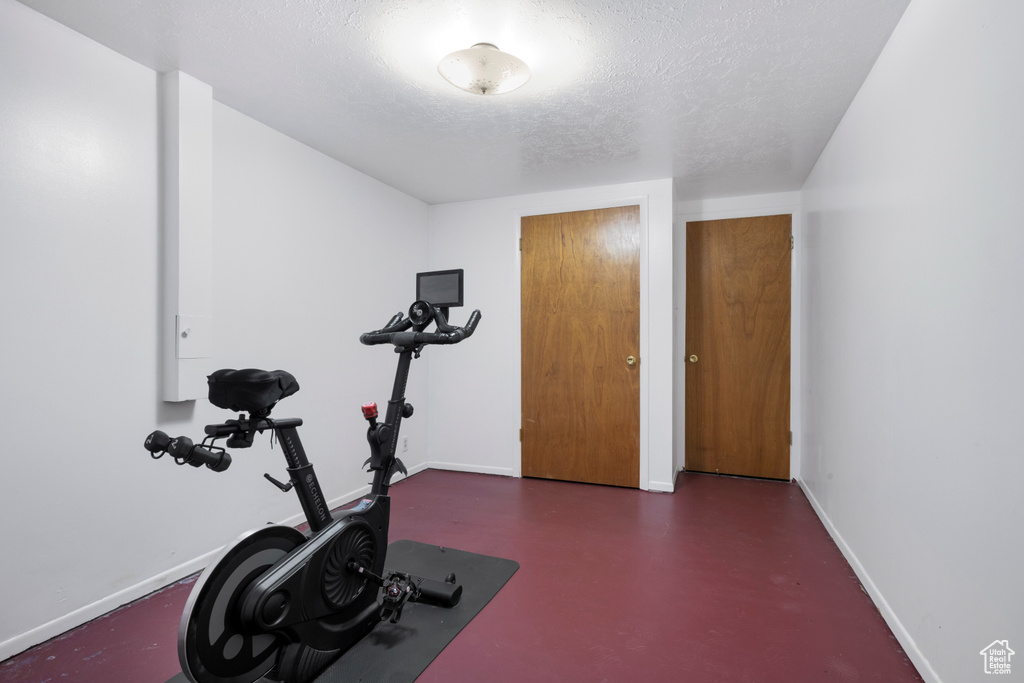 Workout area featuring baseboards and a textured ceiling
