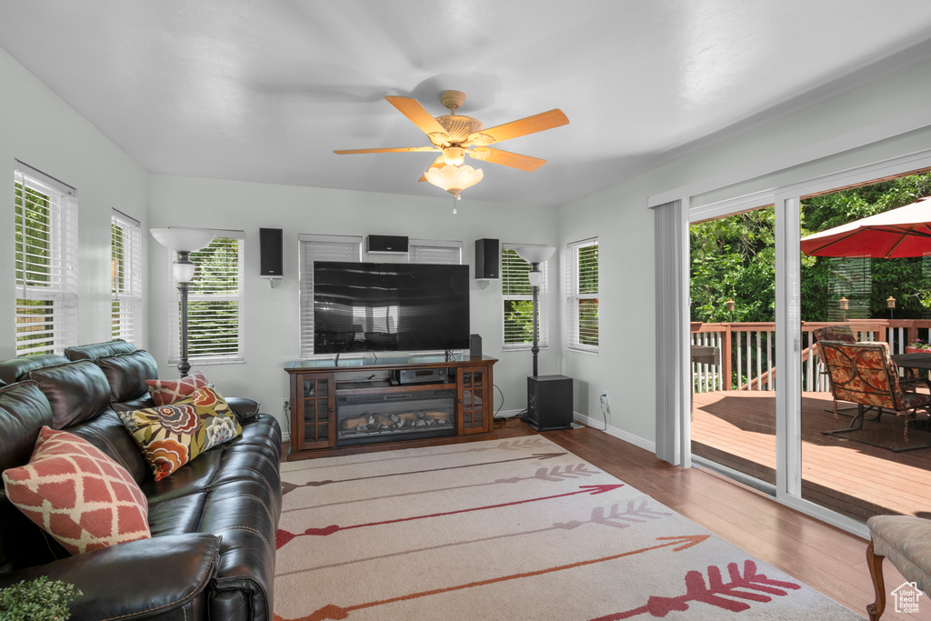 Living area with wood finished floors, a ceiling fan, and baseboards