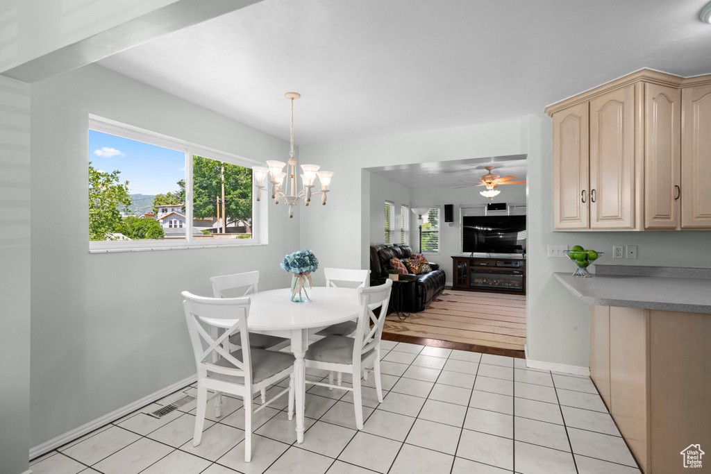 Dining room with plenty of natural light, light tile patterned floors, a chandelier, and baseboards