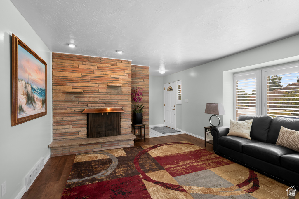 Living room featuring wood finished floors, a fireplace, and baseboards