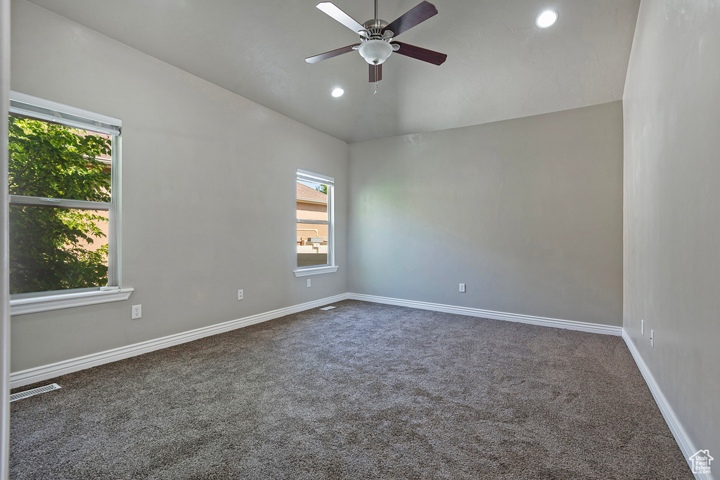 Empty room featuring lofted ceiling, carpet, ceiling fan, baseboards, and recessed lighting