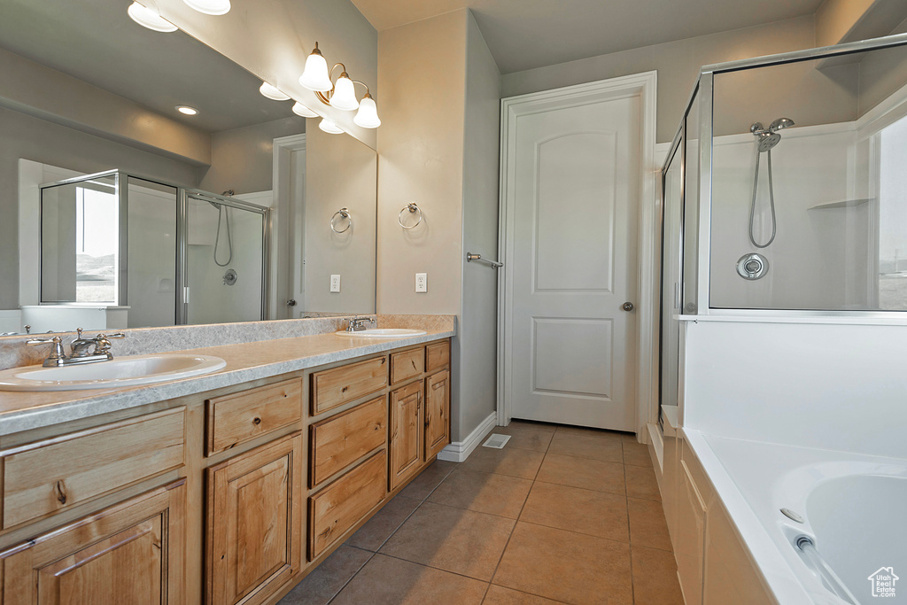Bathroom with a stall shower, tile patterned floors, double vanity, and a garden tub