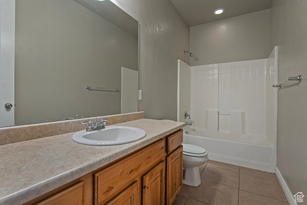 Bathroom with tile patterned floors, vanity, toilet, bathtub / shower combination, and baseboards