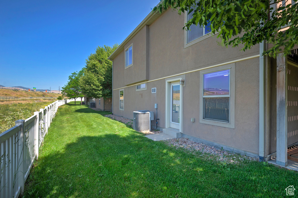 Back of property featuring central AC and stucco siding