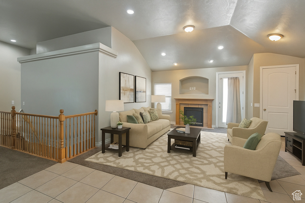 Living room with vaulted ceiling, tile patterned floors, a tiled fireplace, and recessed lighting