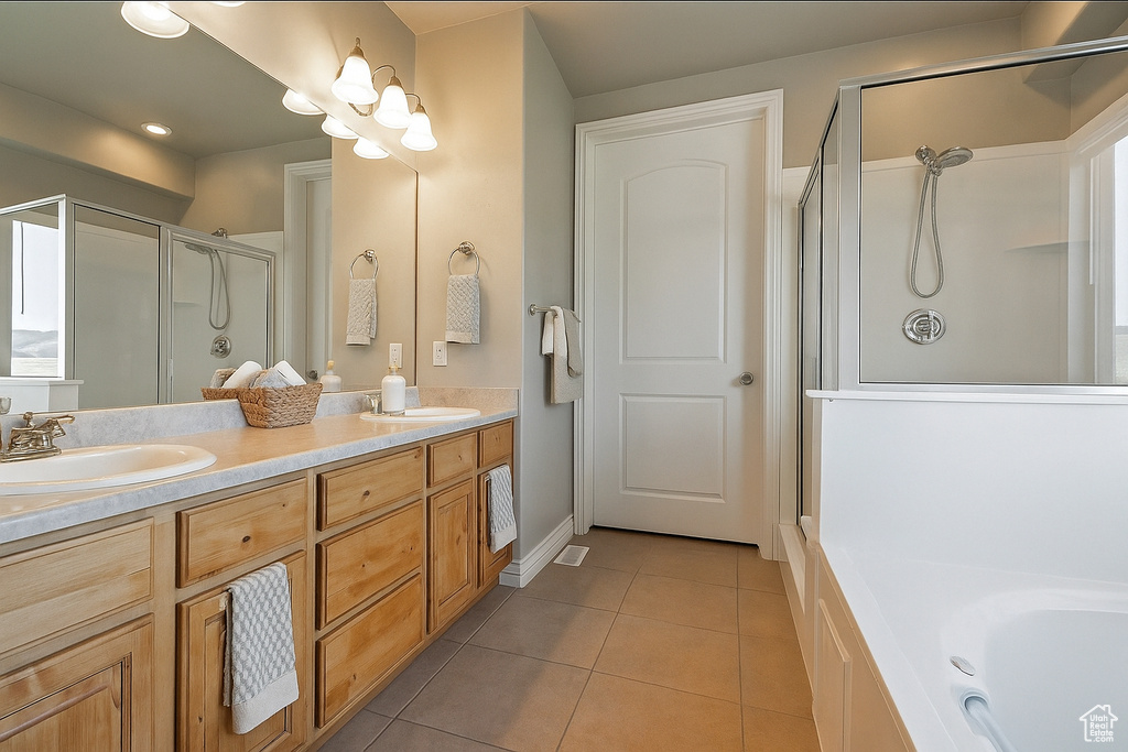 Bathroom featuring a stall shower, tile patterned flooring, double vanity, and a bath