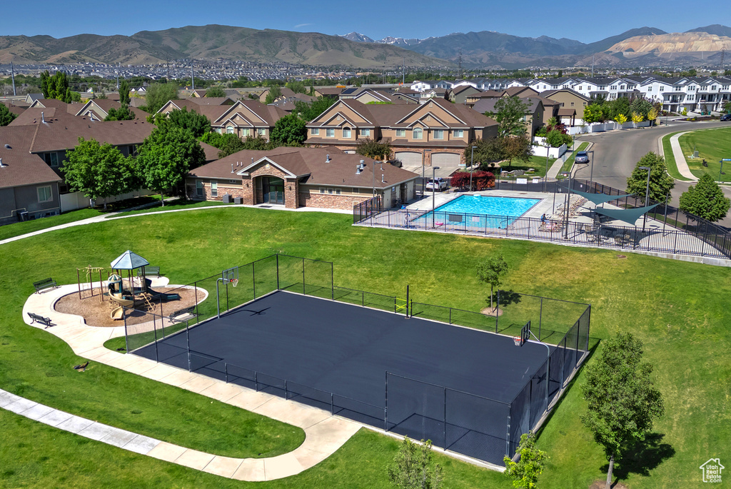 Aerial perspective of suburban area featuring a mountain backdrop and a pool