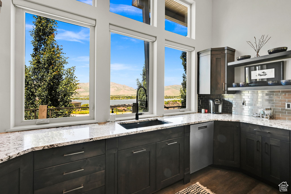 Kitchen featuring a sink, dishwasher, backsplash, dark wood finished floors, and open shelves
