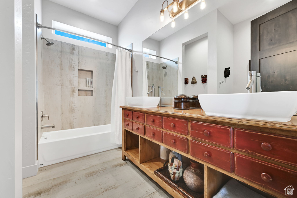 Full bathroom featuring shower / bath combination with curtain, double vanity, and wood finished floors