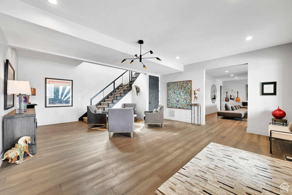 Living area featuring a chandelier, stairway, wood finished floors, recessed lighting, and baseboards
