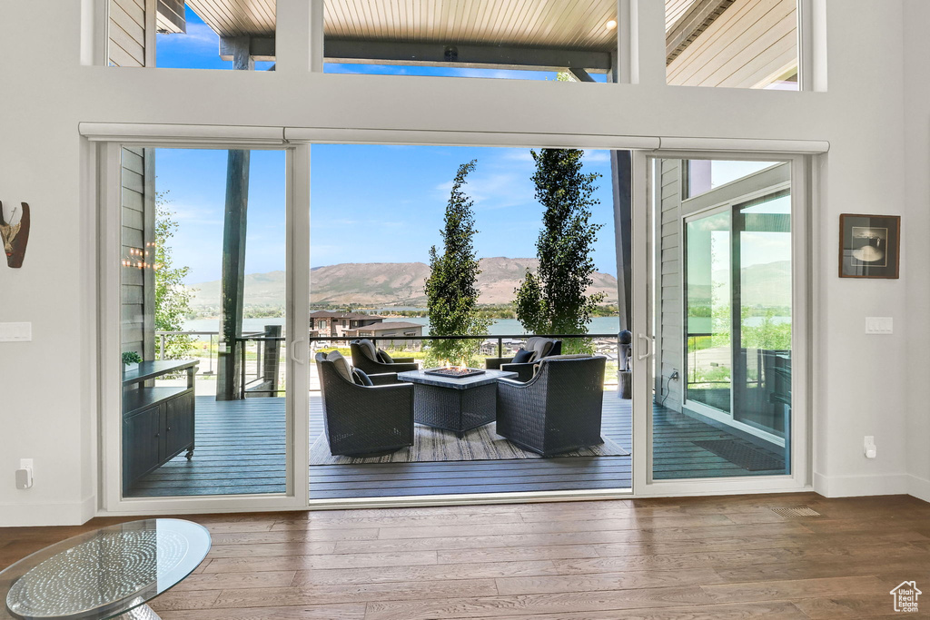 Doorway to outside featuring plenty of natural light, a mountain view, baseboards, and wood-type flooring