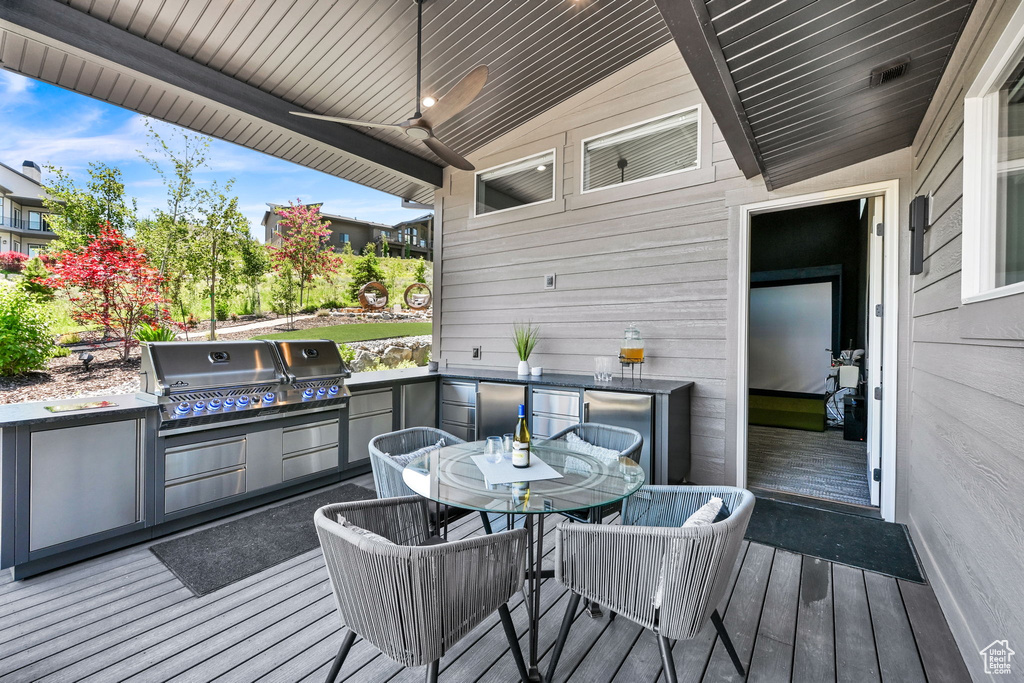 Wooden terrace with outdoor dining space and a ceiling fan