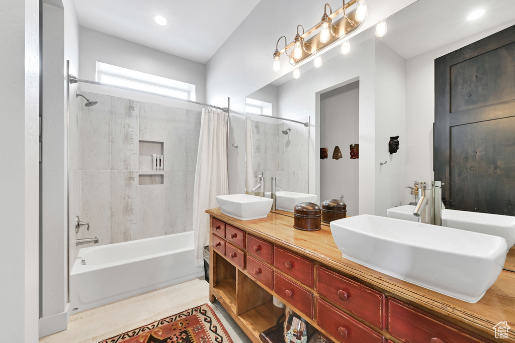 Full bathroom with shower / bath combination with curtain and double vanity