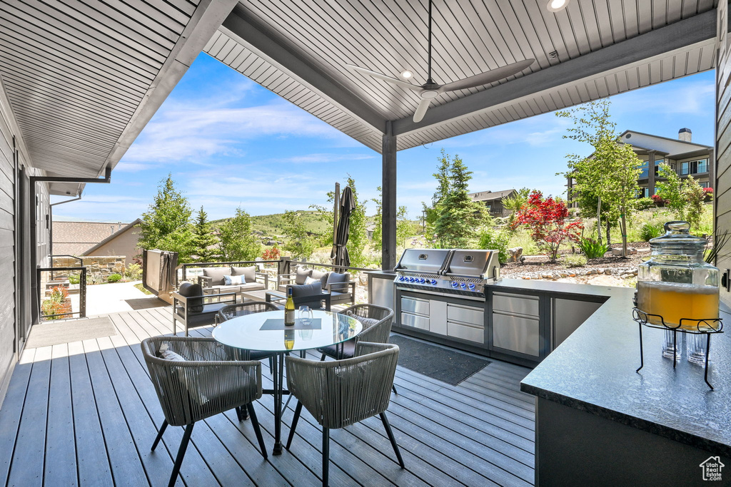 Deck featuring outdoor dining area, an outdoor living space, and a ceiling fan