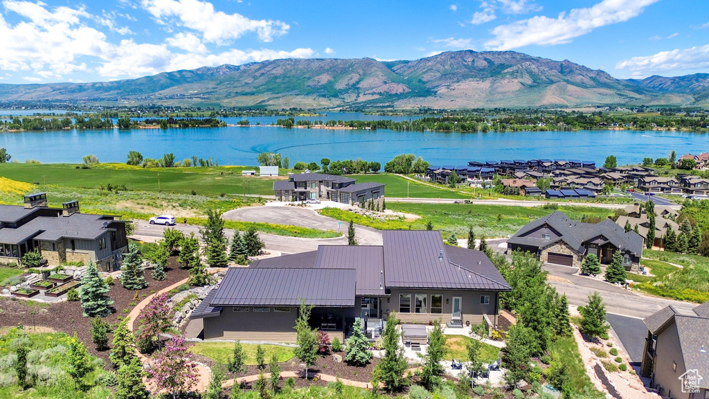 Aerial view of property and surrounding area with a water and mountain view