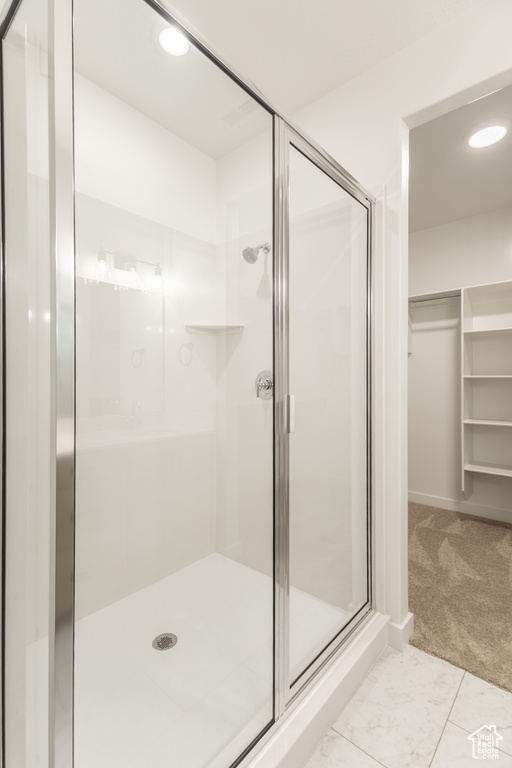 Bathroom with a stall shower, a walk in closet, and recessed lighting