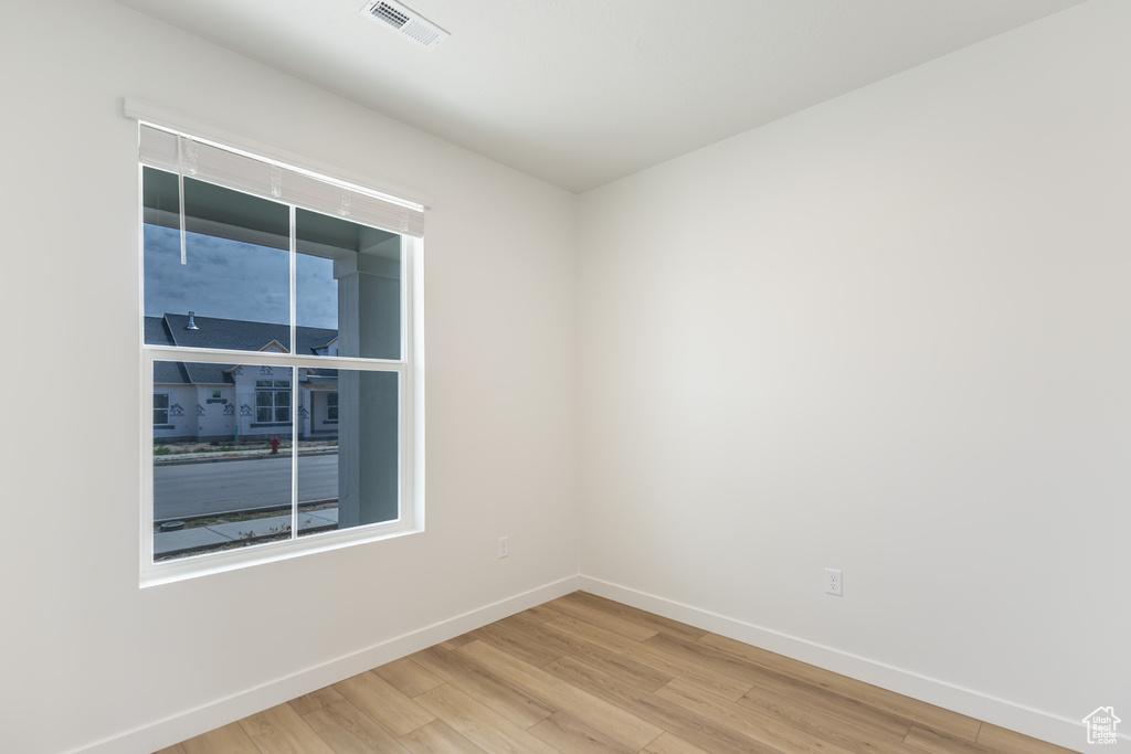 Empty room with light wood-style floors and baseboards