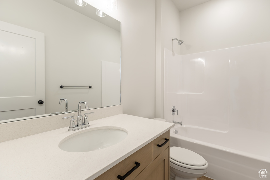Full bathroom with toilet, vanity, and shower / tub combination