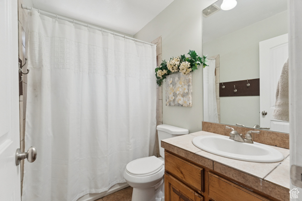 Full bath featuring toilet, vanity, and a shower with shower curtain