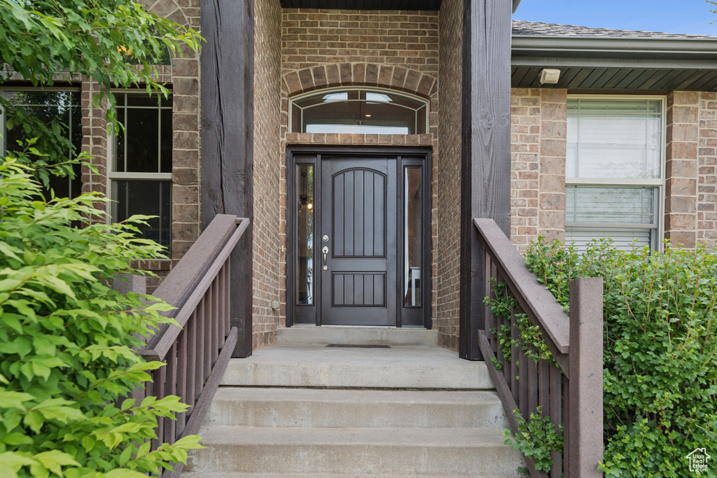 Doorway to property featuring brick siding