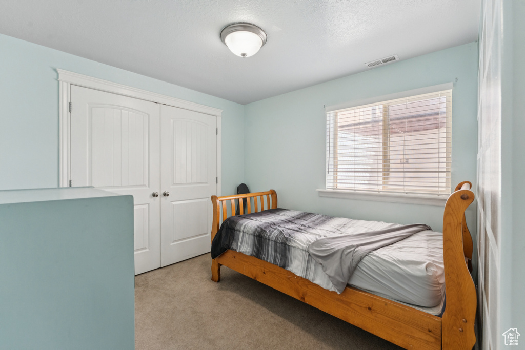 Carpeted bedroom featuring a closet