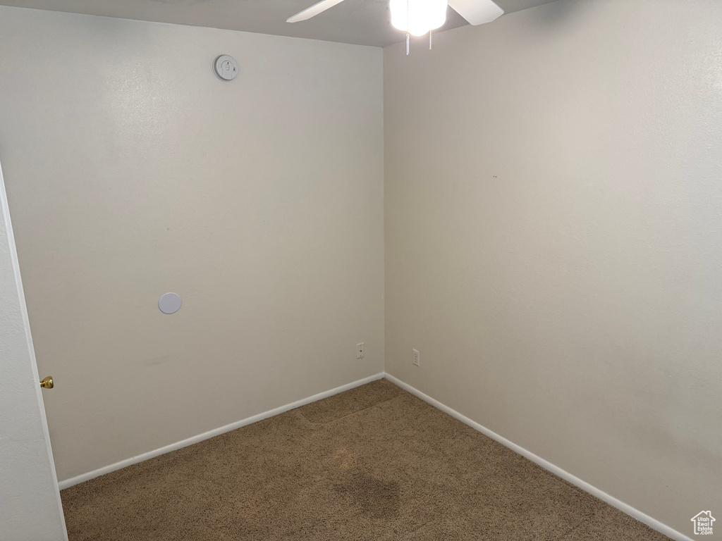 Empty room with carpet, ceiling fan, and baseboards