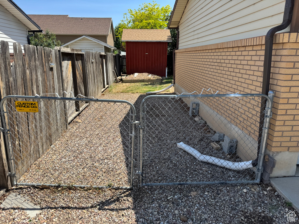 Fenced yard featuring a gate and an outdoor structure