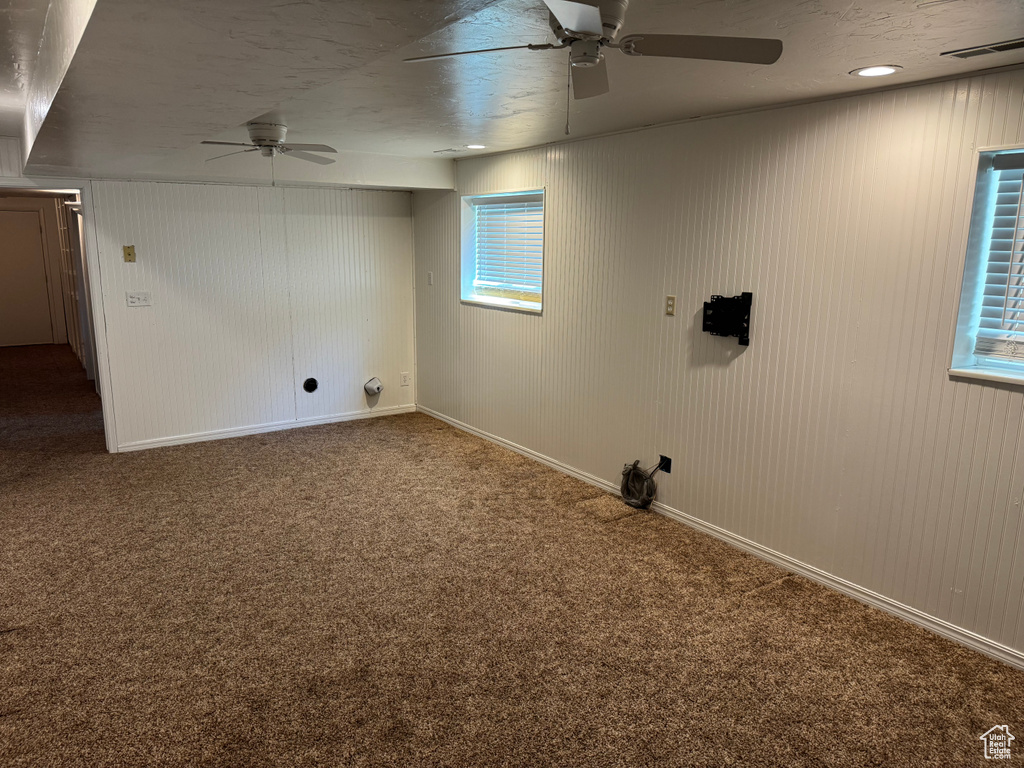Basement with ceiling fan and carpet flooring
