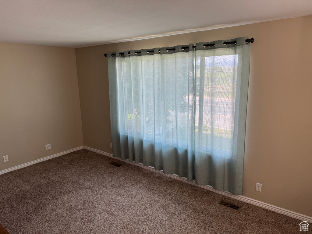 Spare room with carpet and baseboards