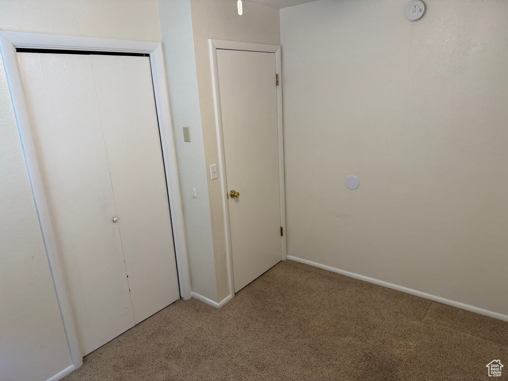Unfurnished bedroom featuring carpet and baseboards
