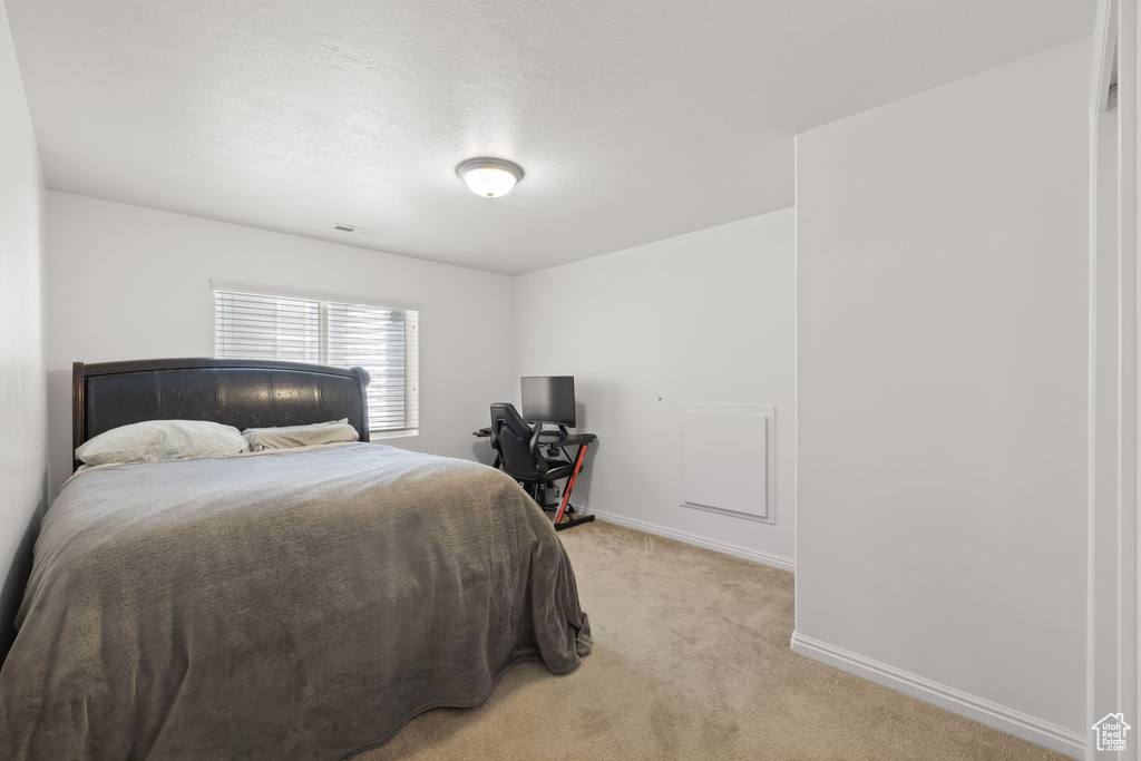 Bedroom with light colored carpet and baseboards
