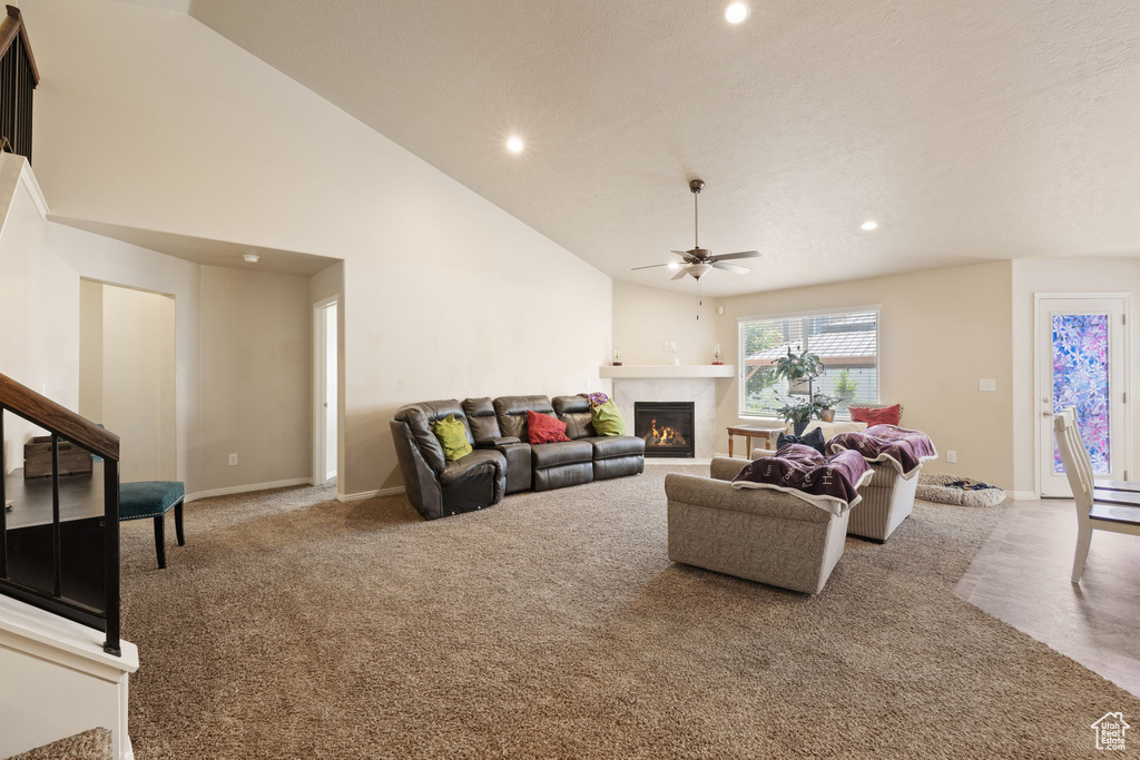 Living room featuring carpet, a ceiling fan, recessed lighting, a tiled fireplace, and baseboards
