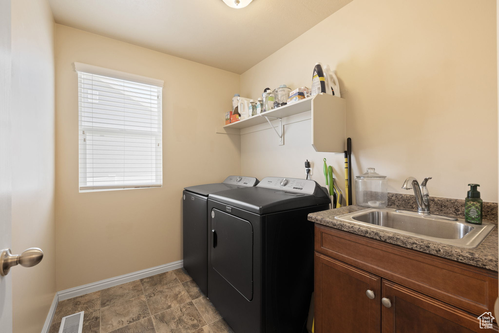 Washroom featuring independent washer and dryer, baseboards, and cabinet space