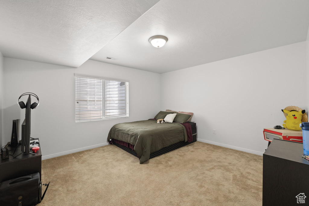 Carpeted bedroom with baseboards and a textured ceiling