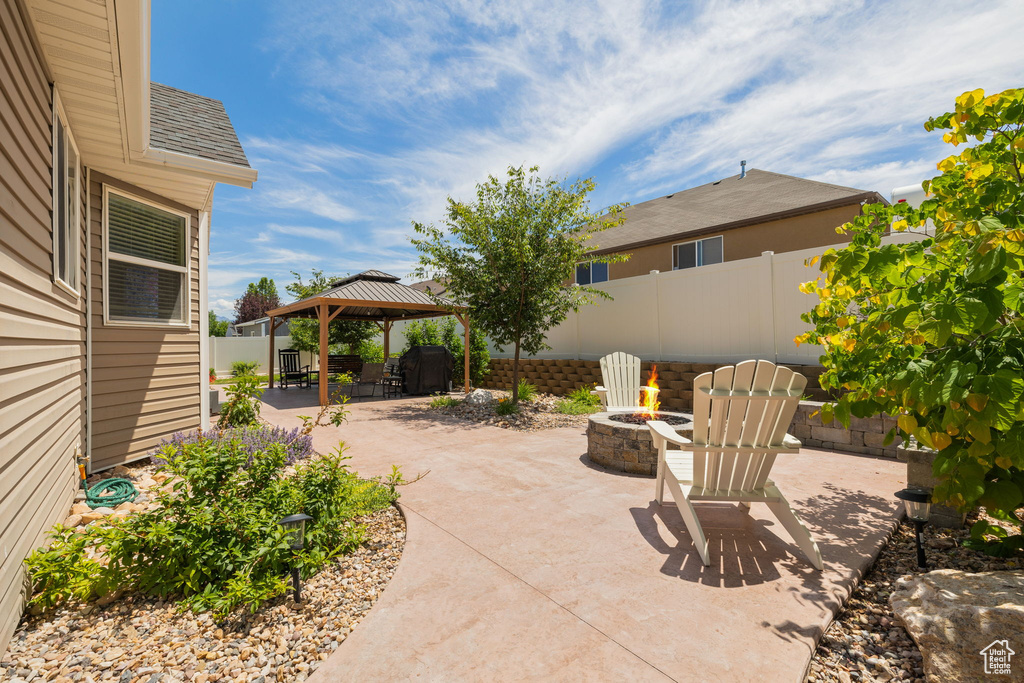 View of patio featuring an outdoor fire pit and a gazebo