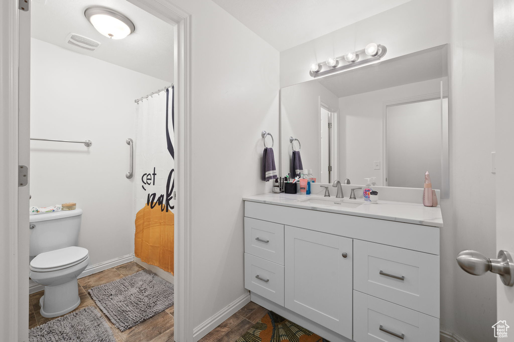 Bathroom featuring vanity, toilet, baseboards, and a shower with curtain