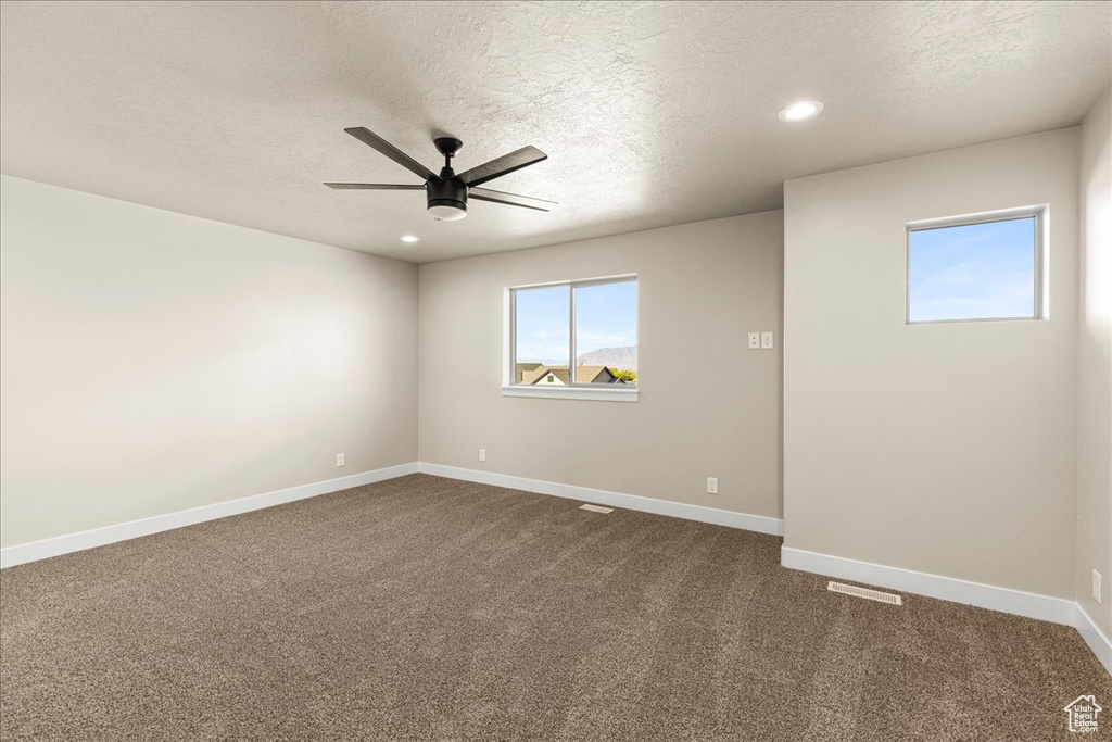 Spare room with ceiling fan, a textured ceiling, baseboards, dark carpet, and recessed lighting