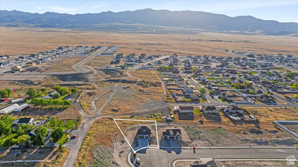 Aerial view of property and surrounding area with a mountainous background