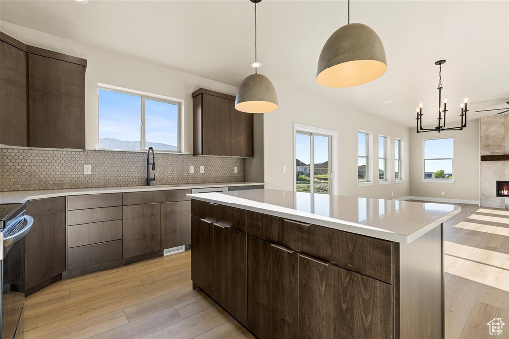 Kitchen featuring a sink, light wood-style flooring, light countertops, and decorative backsplash