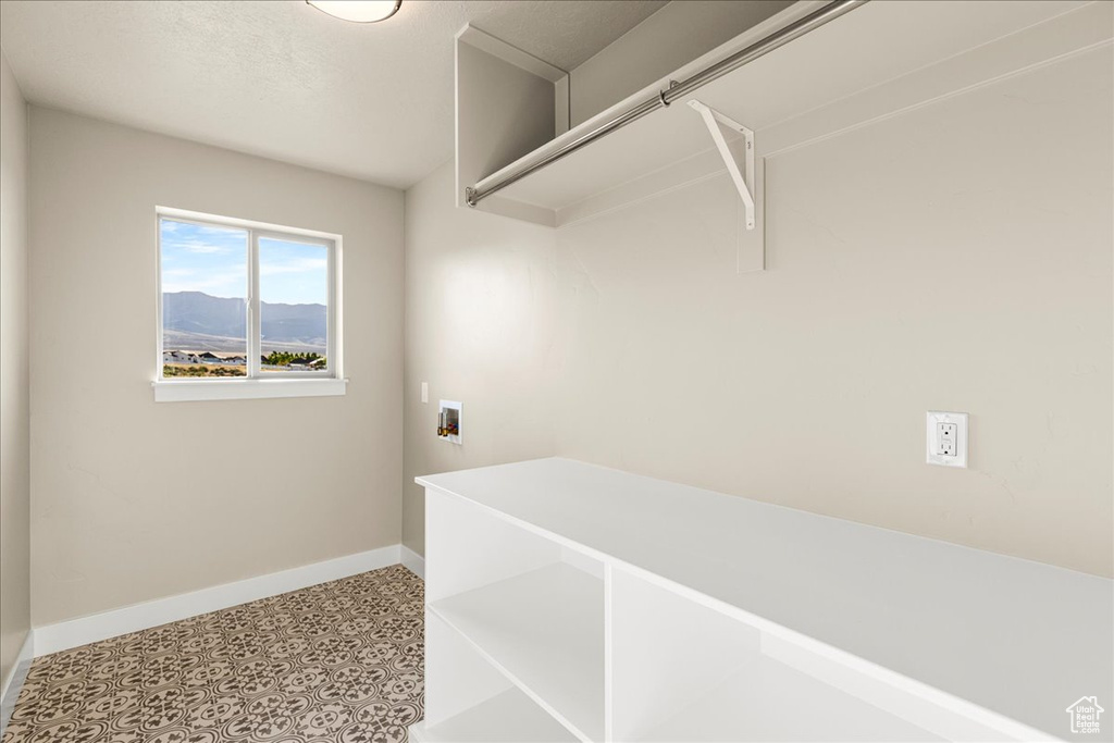 Laundry area featuring baseboards, hookup for a washing machine, and light floors